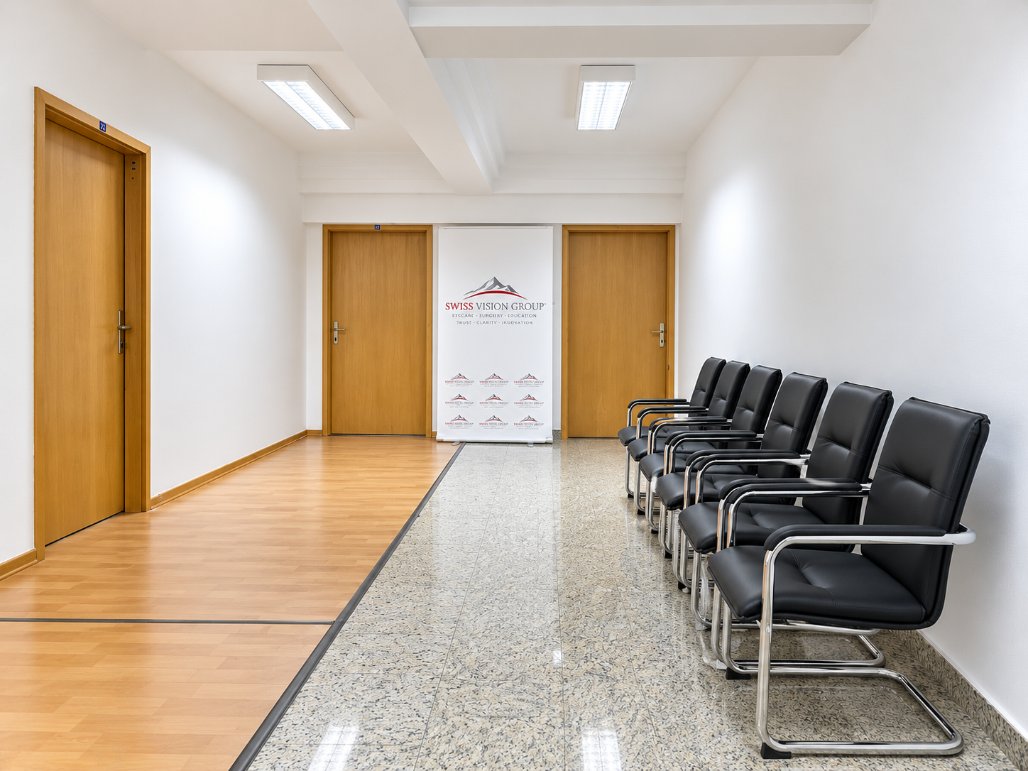 Korridor i ndriçuar i Swiss Vision Group me hapësirë pritjeje